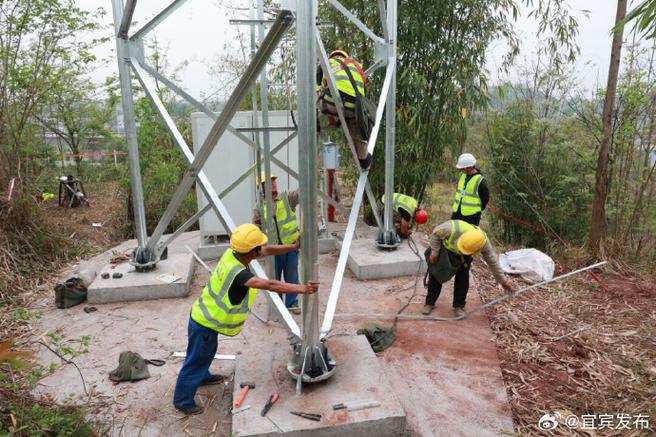 通信基站建设项目施工现场看到,工人正在高空进行5g铁塔塔体安装作业